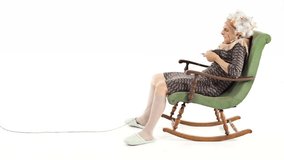 Funny grandmother is knitting on rocking chair - isolated-on-white HD video footage