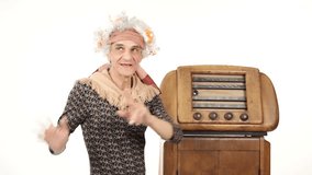 Funny grandmother is dancing listening music to an old radio - isolated-on-white HD video footage