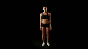 Young athletic woman wearing sporstwear is exercising - slow-motion HD video footage