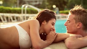 Beautiful young romantic couple have fun at the poolside in summer day - HD video footage