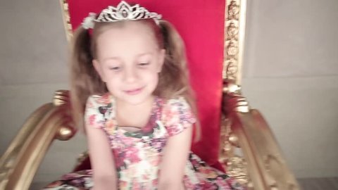 little princess sitting on a throne and looking to camera