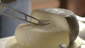 Cutting italian seasoned cheese over cutting board - HD video footage