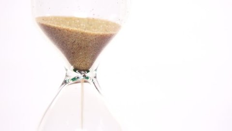 Close-up View of Sand Flowing Through an Hourglass on white background. 4K Ultra HD 3840x2160 Video Clip