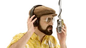Young speaker man dressing 70s yellow-orange vintage clothes and hat talks to microphone - isolated-on-white HD video footage
