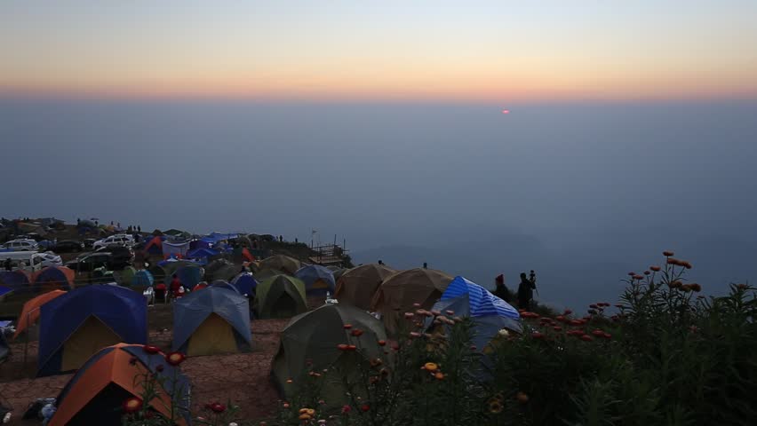 Camping tent field in the first rays of the sun at the top of the mountain