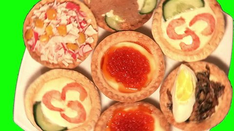 7 different types of tartlets on dish rotating on green screen, top shot, zoom, 