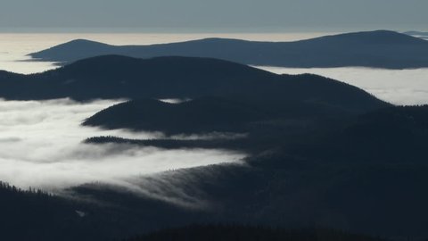 4K - Time lapse during early morning fog rolling over mountainous landscape in the vast forests of the Pacific Northwest, Oregon.