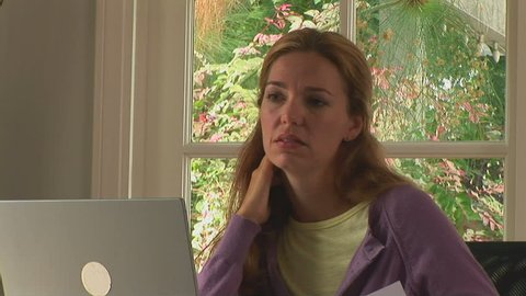 Young woman stressed while working at home with laptop