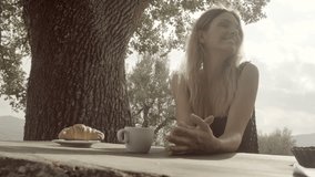 Two young beautiful happy women, friends or lesbian homosexual couple, kiss and smile before italian breakfast on a summer sunny day morning in tuscany, italy - slow-motion HD video footage