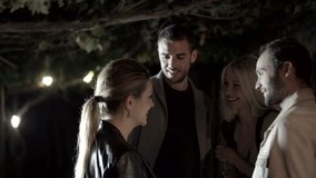 Group of friends laughs, smiles and enjoy in night outdoor - slow-motion HD video footage
