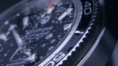 Wrist watch - slow motion / time passing slowly - beautiful macro shot with little drops of water on the glass
