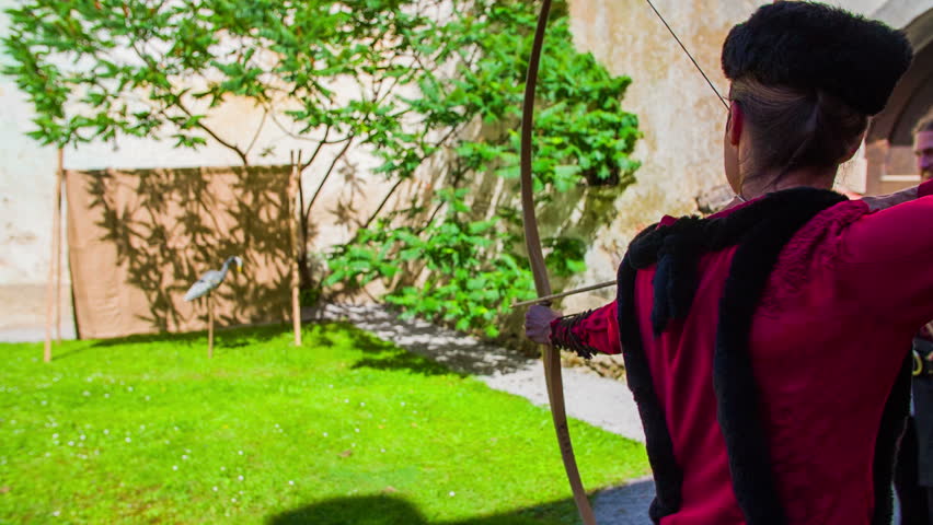 Castle staff practicing archery. On this Close-up slow motion footage is lady of the manor practising archery on the castle from middle ages.