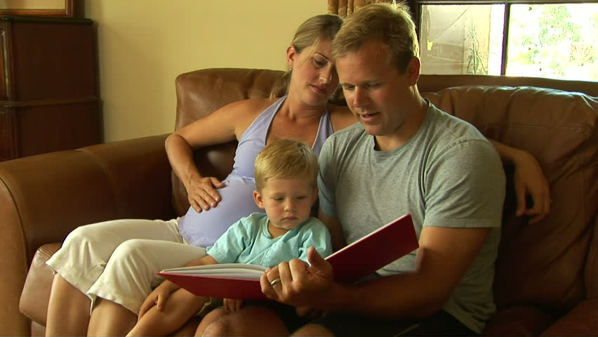 Young pregnant family reading book with toddler | Shutterstock HD Video #875389