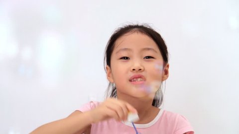 Little girl blows soap bubbles