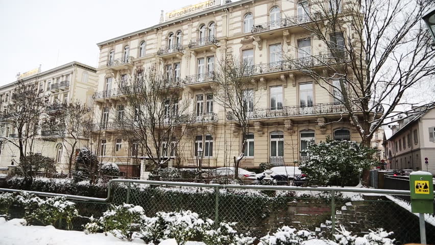 BADEN-BADEN, GERMANY - DECEMBER 29, 2014: A German hotel with snow, wide pan with people. 1080p HD.
