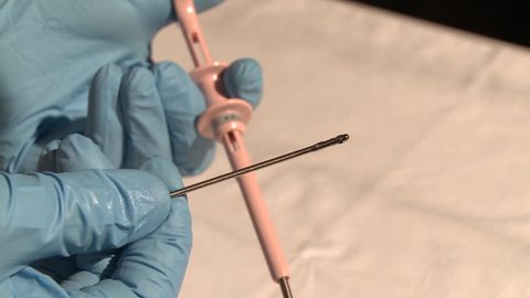 Doctor demonstrates biopsy instrument for biopsy procedure during a bronchoscopic treatment.