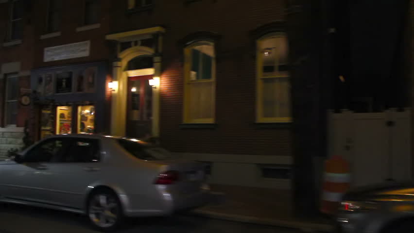 Driving at night in a Pittsburgh suburb.  Storefronts and townhouses are