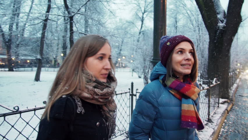 Young happy beautiful girlfriends talking in city
