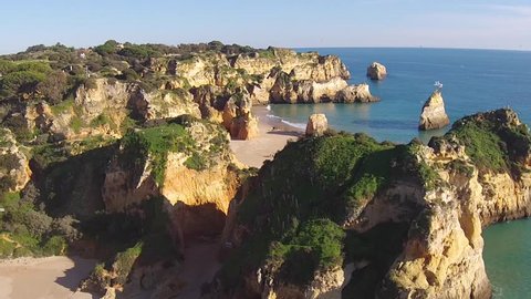 Aerial from rocks and ocean at Praia Tres Irmaos in Alvor the Algarve Portugal