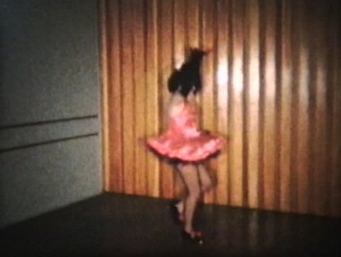 A teenage girl wearing a pink dress goes through her tap dancing routine.  Stock Video