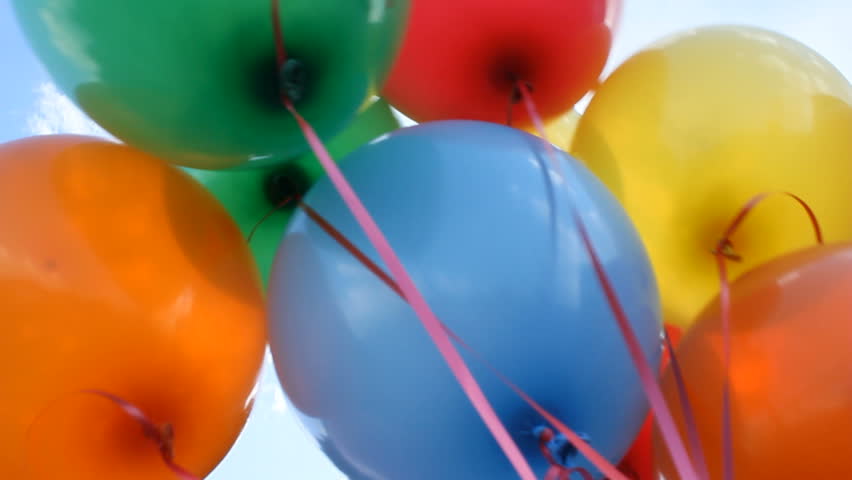 Colorful helium balloons fly up into the sky