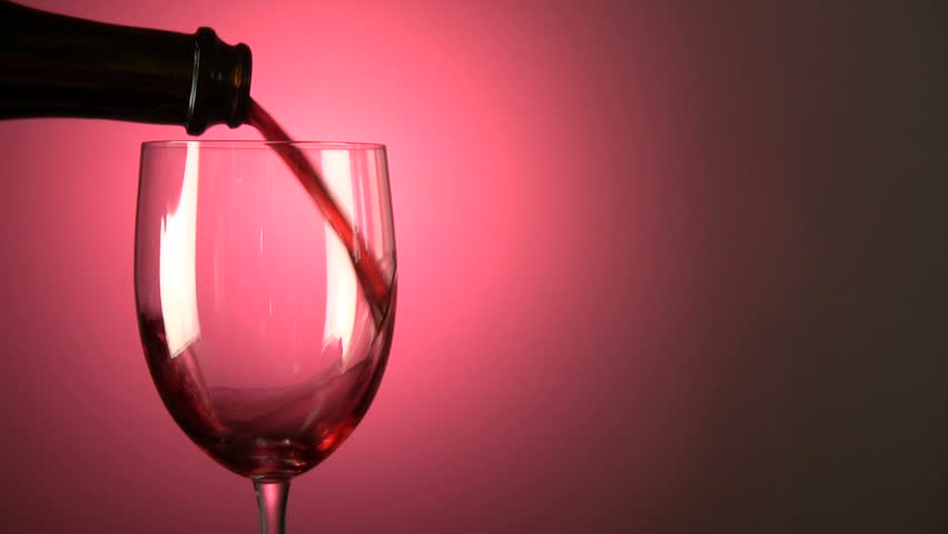 Red wine pours into a glass with space for copy