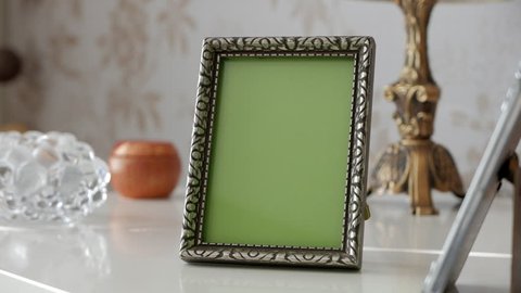 Single Picture Frame with Green Screen on side table. With decoration around. Tracking shot Stock Video