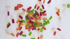 Colorful gummy bears falling in slow motion full HD footage top view