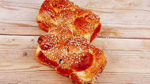 hot bun of light wheat bread topped by sesame seeds on wood 1920x1080 intro motion slow hidef hd
