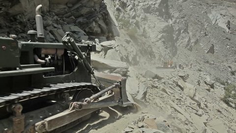 HIMACHAL PRADESH, INDIA - JUNE 30, 2012: Bulldozers cleaning mountain road after landslide in Himalayas. 