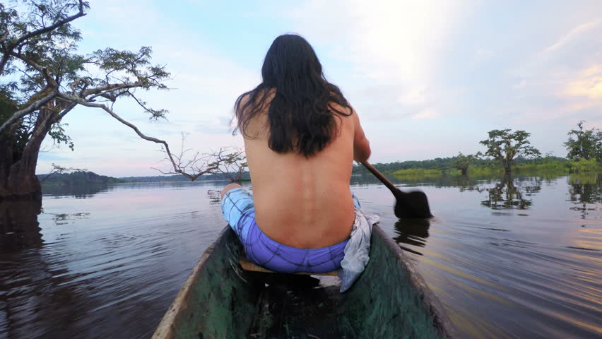 Indigenous Men On Wooden Canoe On Board Camera Shot From The Back Side Of Boat Against Beautiful Sunset