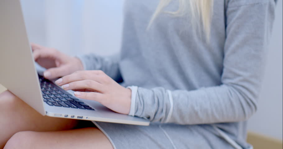 Blurred Smiling Blond Woman Using her Laptop Computer While Leaning on White Wall  Emphasizing her White Laptop. | Shutterstock HD Video #8790103