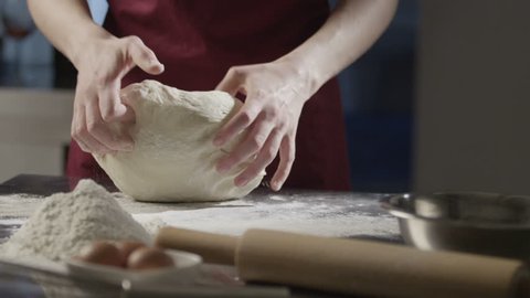Man chef kneads the dough shot on 4K RED camera