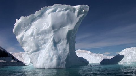 Camera pans around a small blue iceberg in Neko Harbour, Antarctica. Taken from a Zodiac boat

