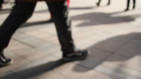 Defocused silhouettes of people walking on the street
