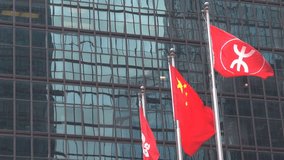 Modern skyscraper with Chinese flag blow wind in Hong Kong financial district by day  - Powered by Shutterstock - Get 15% off with code: PIKWIZARD15