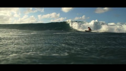 A surfer performs tricks and turns on a nice little wave in slow motion