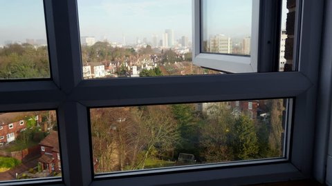 City view, camera tracking through a window.
Camera tracks out through a high rise building window to frame a city view.