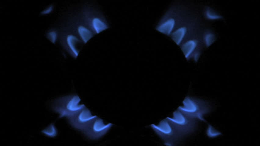 Blue flames of gas stove on the black background 