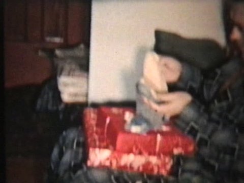 A family spend time together around the Christmas tree opening up gifts and presents to each other. Stock Video