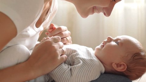 Mother kissing her child (slow motion): film stockowy