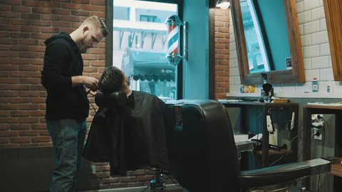 Barber shave the beard of the client with trimmer