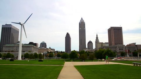 The skyline of Cleveland, Ohio as seen from the shore of Lake Erie.  The windmill at the Great Lakes Science Center is seen in the foreground. Stock Video