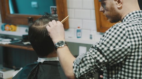 Barber cuts the hair of the client with clipper