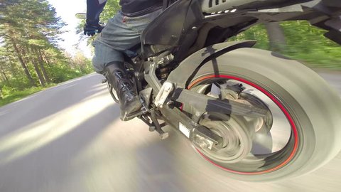 Riding a motorcycle, view on rear wheel