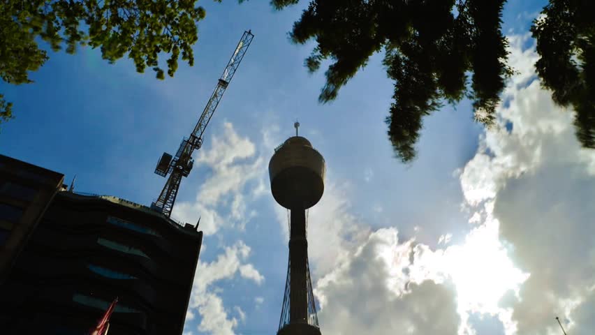 Sydney Tower Silhouette Against Fast Moving Clouds And Sun Flares, Time Lapse