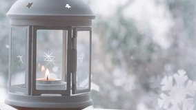 Candle burning inside of the white lantern next to the window during winter and Christmas holidays. It's snowing outside. Dolly shot.
Video developed from RAW. - Powered by Shutterstock - Get 15% off with code: PIKWIZARD15