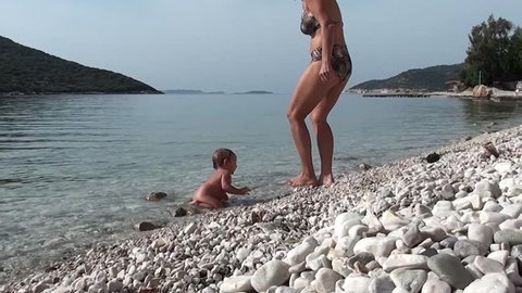 Mother joins baby at shallows with love and care