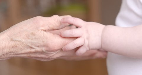 tender baby hands touching senior hands 60fps