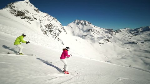 couple skiing on ski piste side view स्टॉक वीडियो